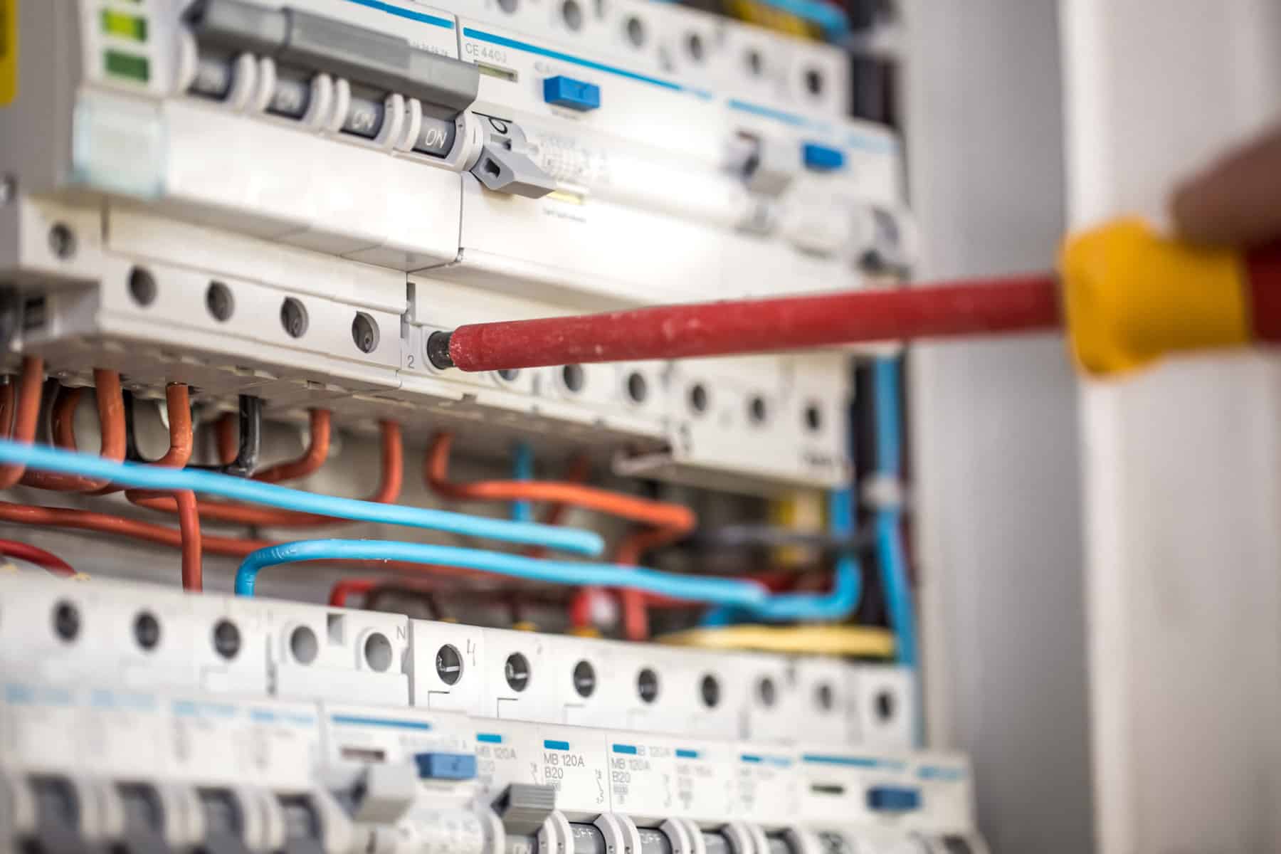 Technician working on electrical switchboard